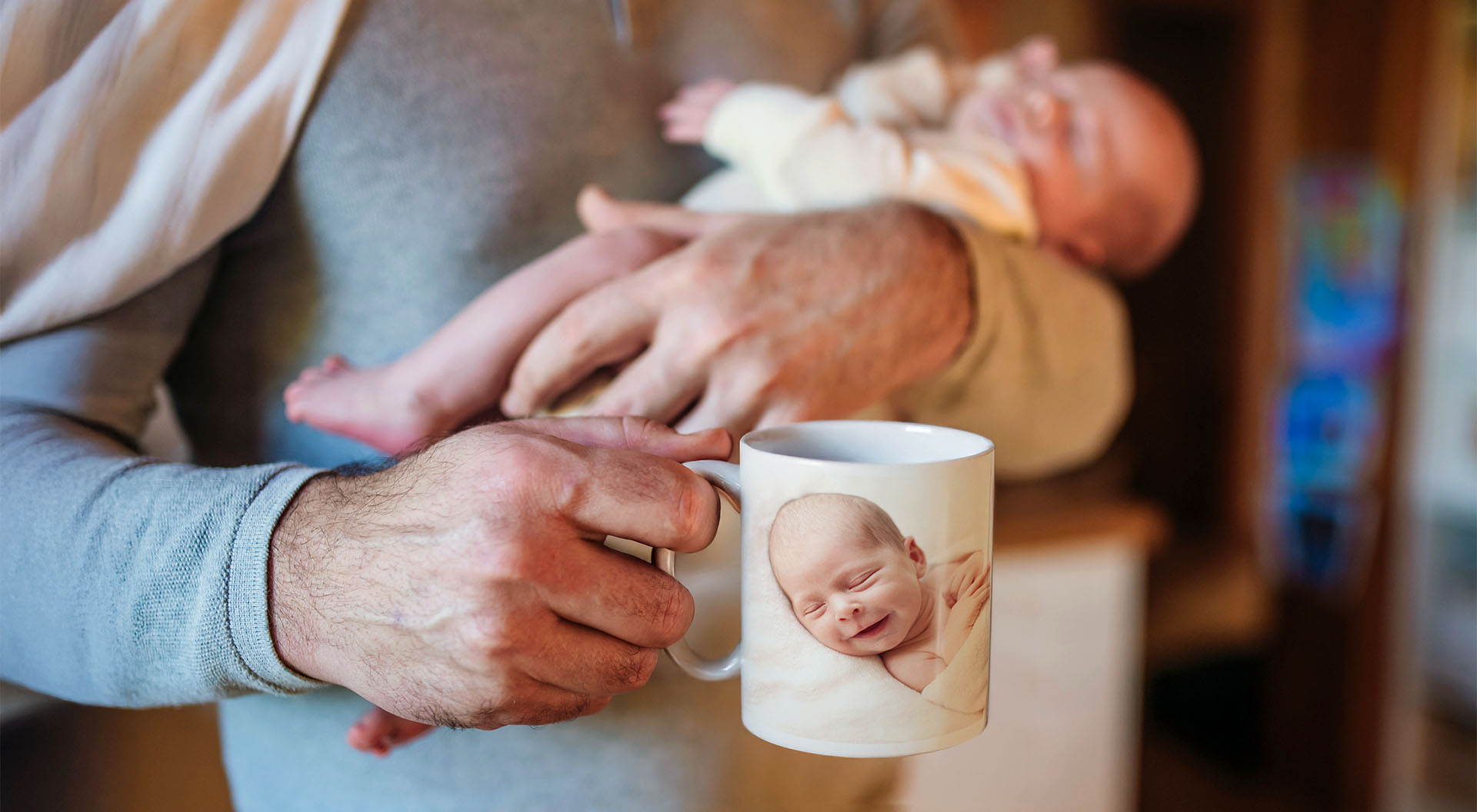 Man håller en fotomugg med en bild av en bebis
