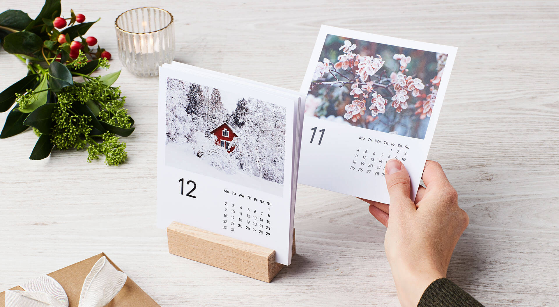 Pöytäkalenterissa on kätevä puuteline jossa kuukausikortit pysyvät pystyssä