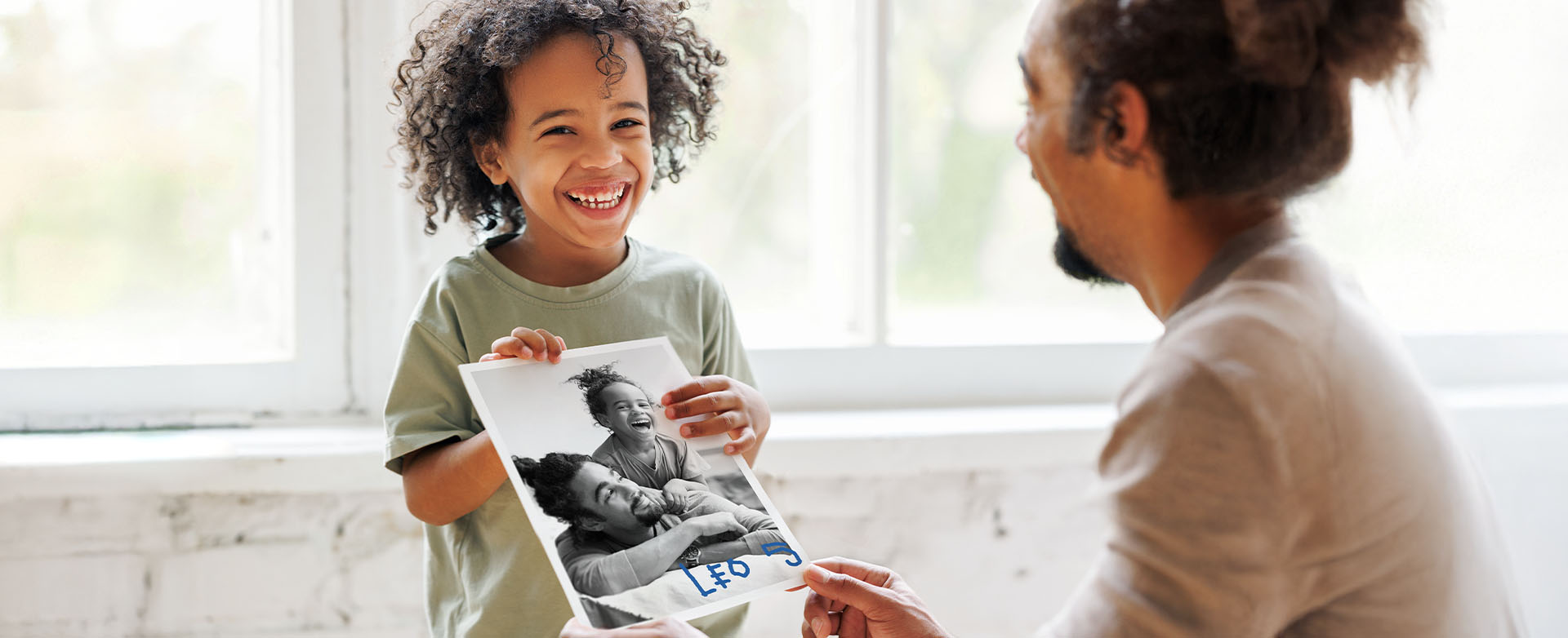 Lapsi ojentaa isänpäiväkorttia isälleen